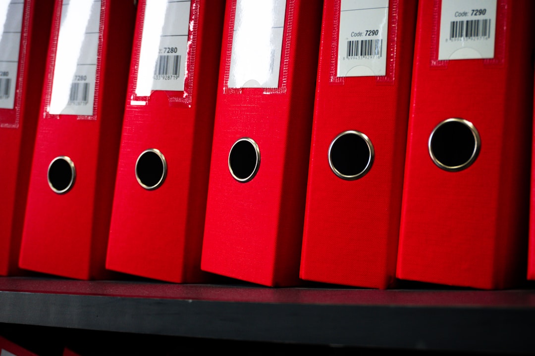 secure document workflow with a keyboard and lock — Photo by Zulfugar Karimov on Unsplash. Source: https://unsplash.com/photos/red-file-folders-are-neatly-arranged-on-a-shelf-SiJt15u6Yw4
